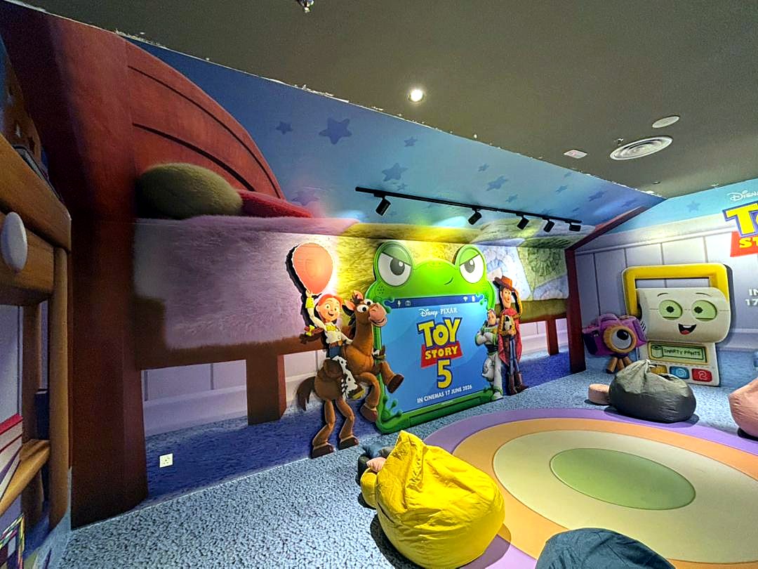 Interior of the Toy Story 5 activation with character cutouts and bean bag seating